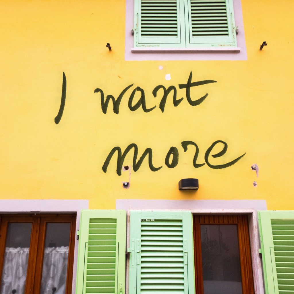 Wand mit Graffiti-Aufschrift "I want more"